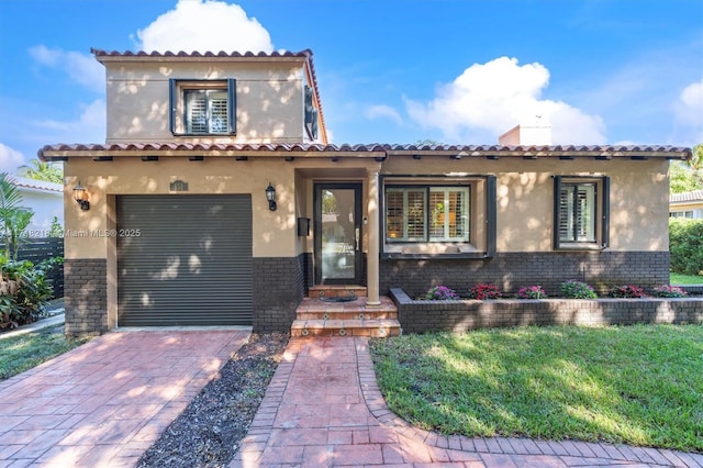 mediterranean / spanish home with a garage and a front lawn