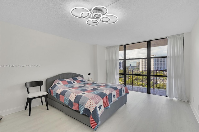 800 Parkview Dr Unit 1001, Hallandale Beach, FL 33009 - bedroom with wood finished floors, a wall of windows, a textured ceiling, and baseboards