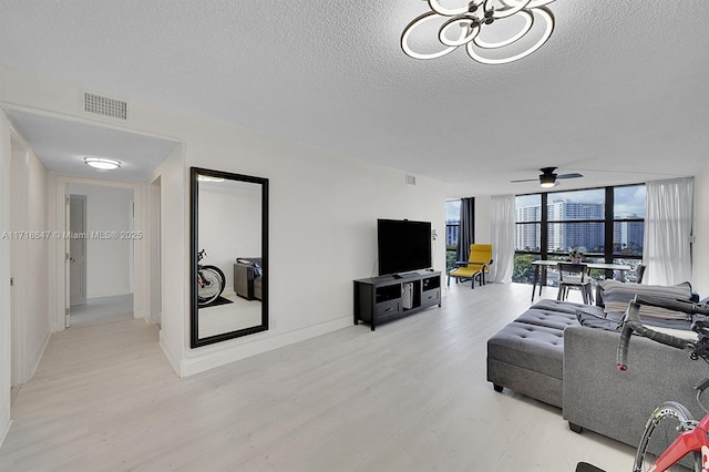 800 Parkview Dr Unit 1001, Hallandale Beach, FL 33009 - living room featuring light wood-style floors, floor to ceiling windows, a textured ceiling, a ceiling fan, and a chandelier