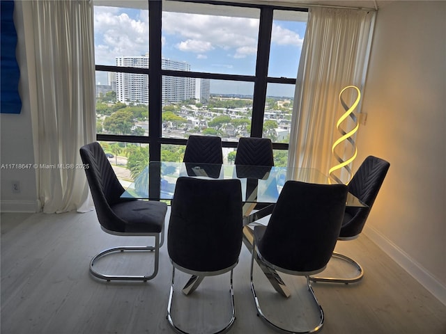 800 Parkview Dr Unit 1001, Hallandale Beach, FL 33009 - dining room with baseboards, wood finished floors, a city view, and healthy amount of natural light
