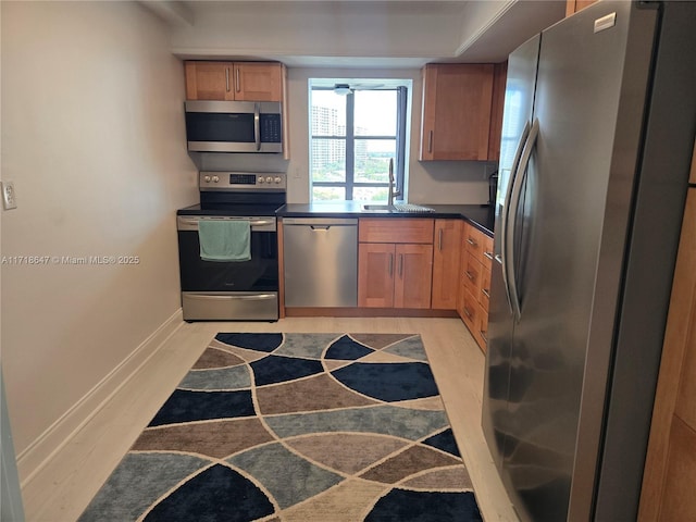 800 Parkview Dr Unit 1001, Hallandale Beach, FL 33009 - kitchen featuring stainless steel appliances, a sink, dark countertops, a ceiling fan, and baseboards