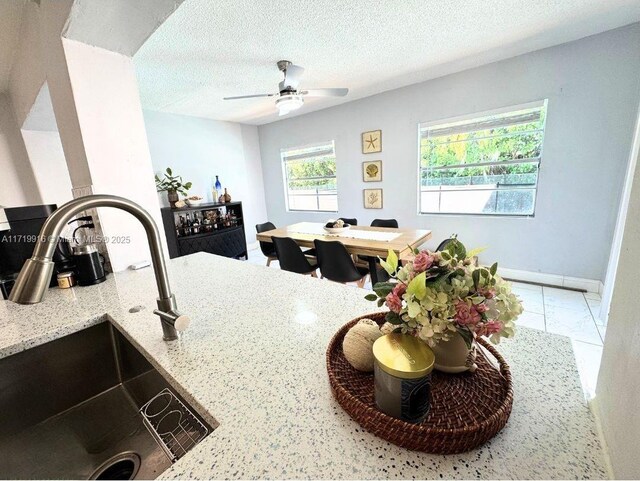 kitchen with light stone counters, stainless steel appliances, white cabinetry, and backsplash