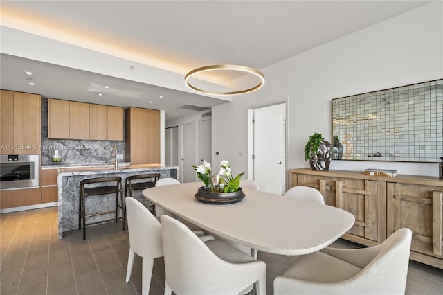 dining space featuring dark wood-type flooring and recessed lighting