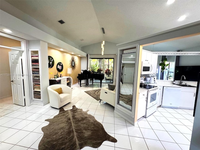 kitchen with white cabinetry, white appliances, light tile patterned flooring, lofted ceiling, and sink