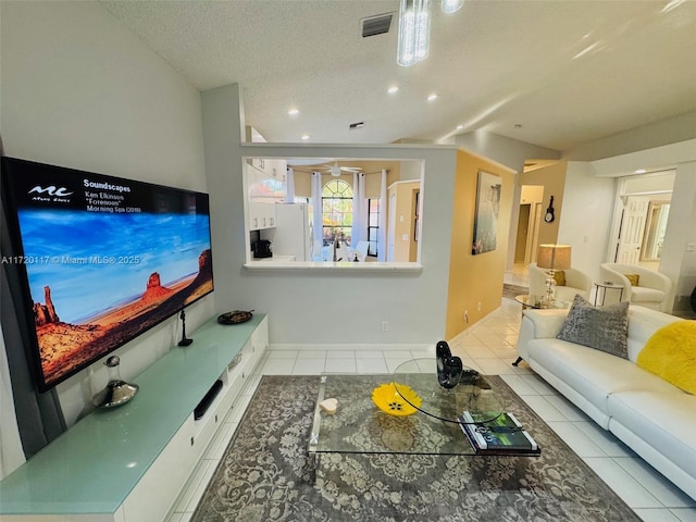 living room with a textured ceiling and light tile patterned floors