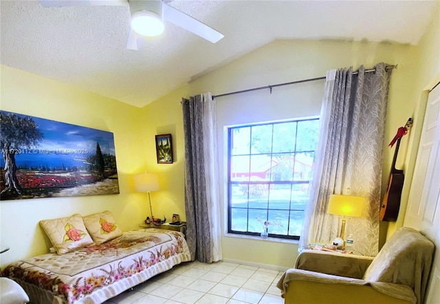 sitting room featuring vaulted ceiling, light tile patterned flooring, a ceiling fan, and a healthy amount of sunlight