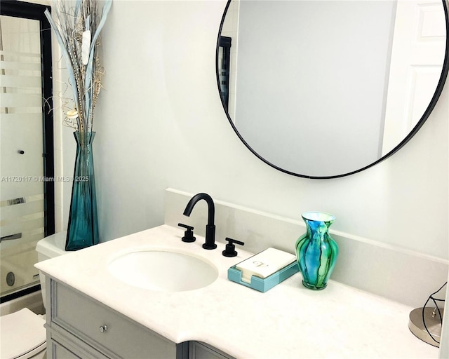 bathroom featuring toilet, shower / bath combination with glass door, and vanity