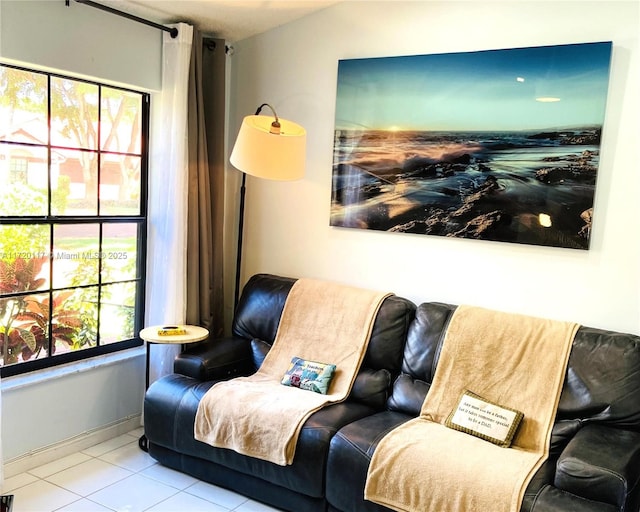 living area featuring baseboards and light tile patterned floors