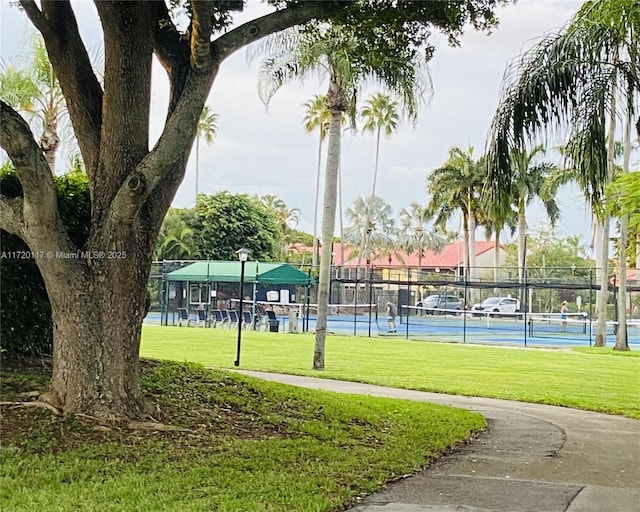 view of property's community featuring a lawn and fence