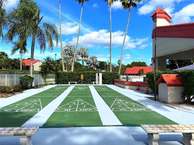 view of property's community with fence and shuffleboard