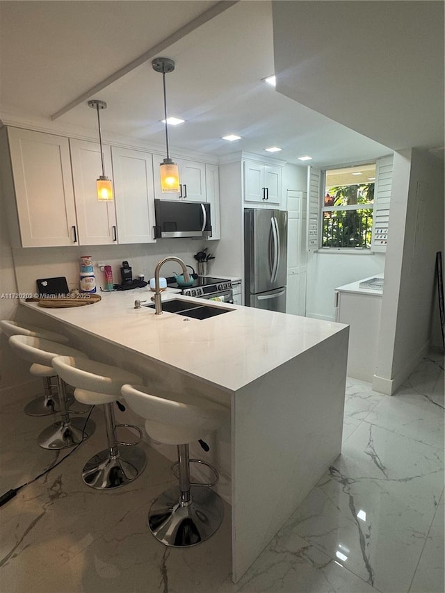 kitchen with pendant lighting, sink, white cabinetry, and stainless steel appliances