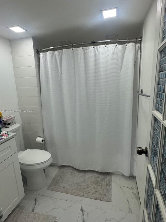 bathroom featuring vanity, toilet, and walk in shower