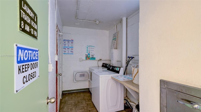 laundry area with washer and clothes dryer and dark parquet flooring