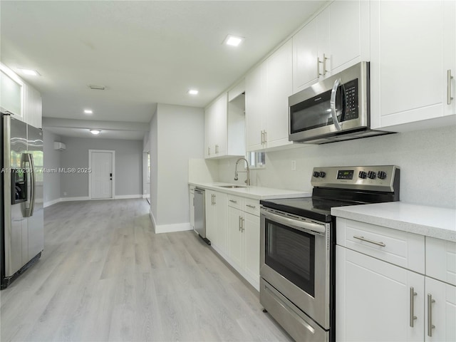 kitchen with appliances with stainless steel finishes, white cabinetry, and sink