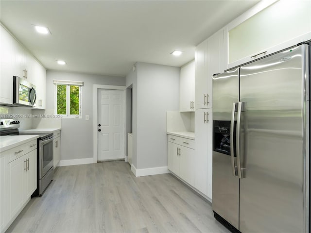 kitchen featuring white cabinetry, backsplash, appliances with stainless steel finishes, and light hardwood / wood-style flooring