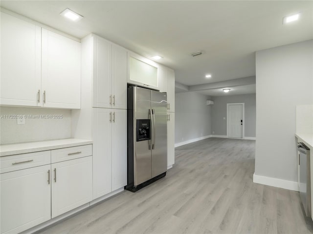 kitchen with white cabinetry, appliances with stainless steel finishes, and light hardwood / wood-style flooring