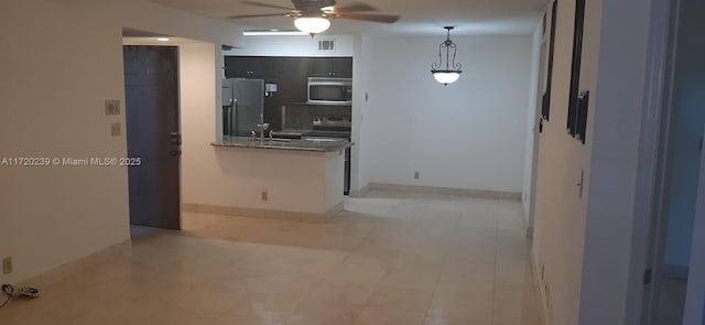 kitchen with stone counters, sink, ceiling fan, hanging light fixtures, and appliances with stainless steel finishes