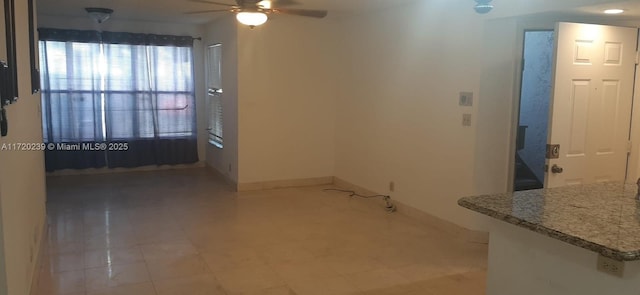 interior space with ceiling fan and light tile patterned flooring