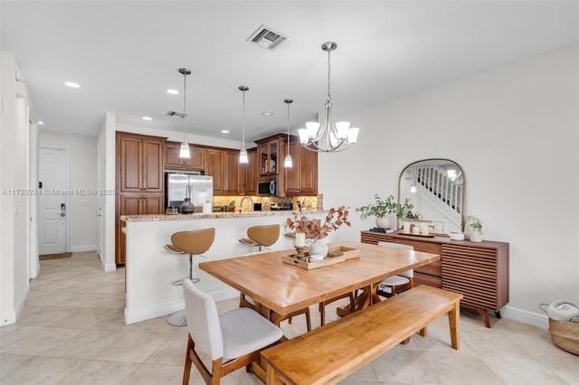 tiled dining space with a notable chandelier and sink