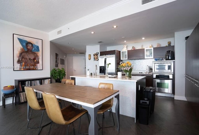 dining room featuring sink, dark hardwood / wood-style flooring, and crown molding