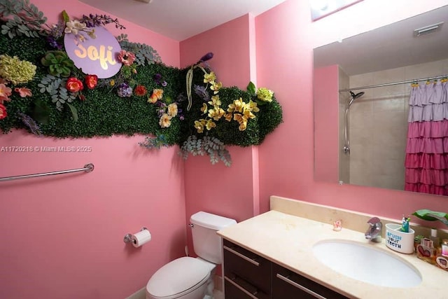 bathroom featuring a shower with curtain, vanity, and toilet