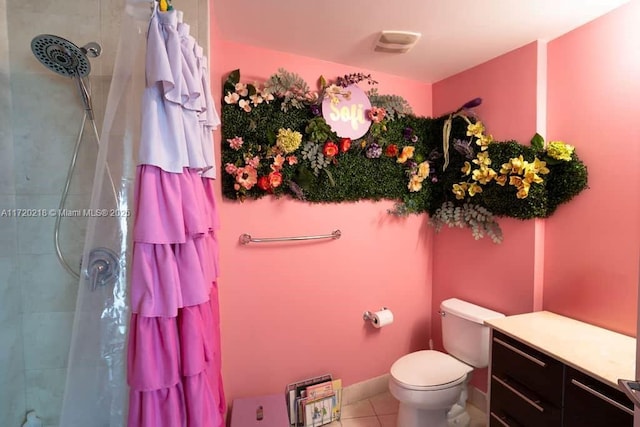 bathroom featuring tile patterned floors, toilet, and a tile shower