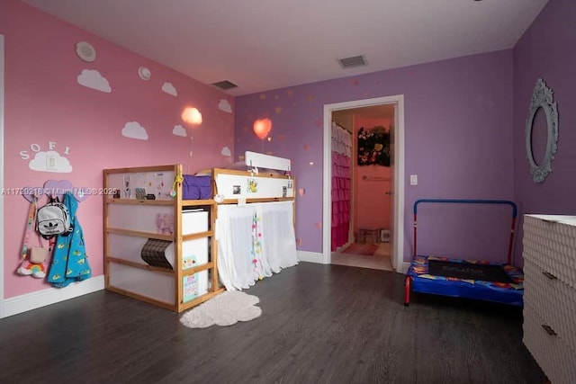 bedroom featuring ensuite bath and dark wood-type flooring