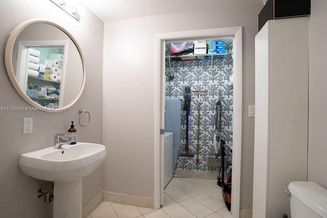 bathroom featuring tile patterned flooring, toilet, walk in shower, and sink