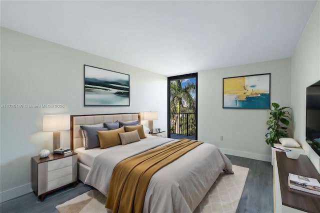 bedroom featuring dark wood-type flooring and access to outside