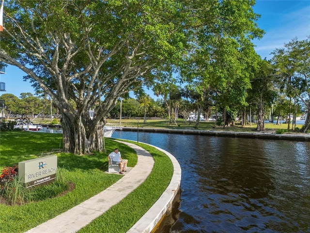 surrounding community featuring a water view and a lawn