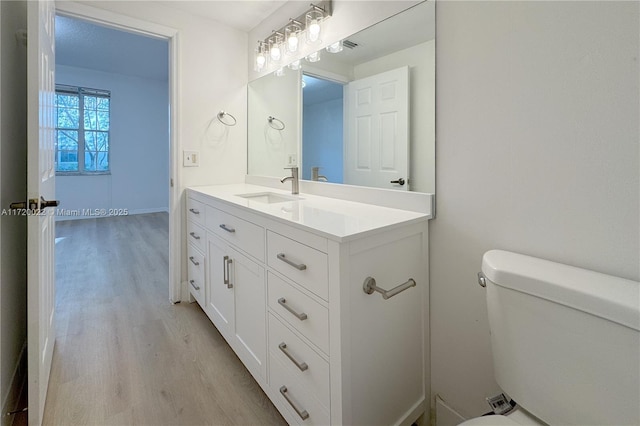 bathroom featuring hardwood / wood-style floors, toilet, and vanity