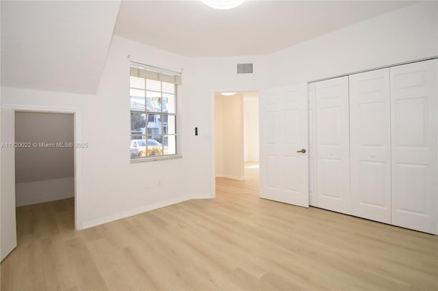 unfurnished bedroom with light hardwood / wood-style floors and a closet