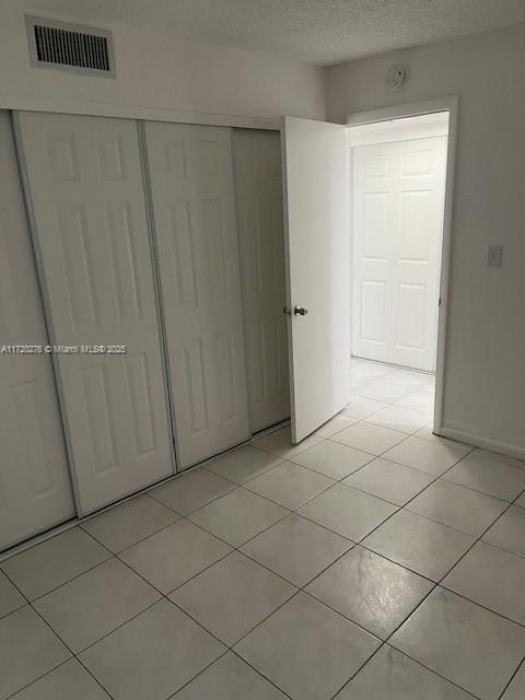 unfurnished bedroom with a closet and light tile patterned floors