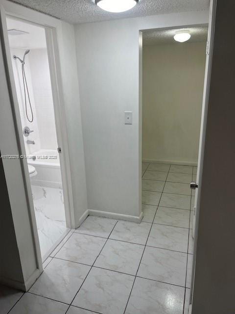 hallway with a textured ceiling