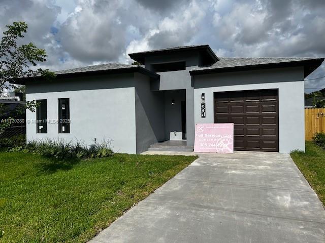 301 NW 28th Ave, Fort Lauderdale, FL 33311 - prairie-style house with an attached garage, driveway, and stucco siding