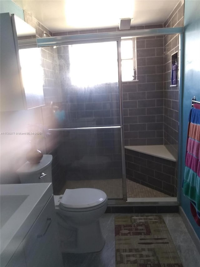 bathroom featuring vanity, toilet, an enclosed shower, and tile walls