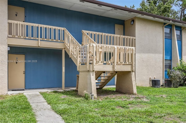 doorway to property with a lawn and central air condition unit