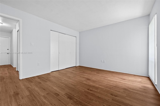 unfurnished bedroom featuring a closet and wood-type flooring