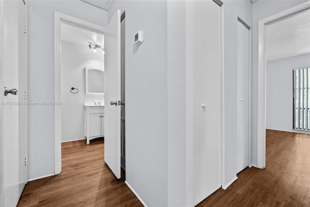 hall with sink and wood-type flooring