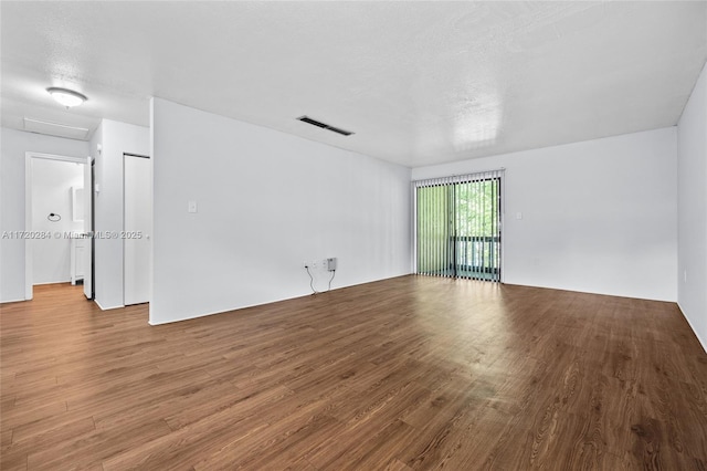 unfurnished room featuring hardwood / wood-style floors and a textured ceiling