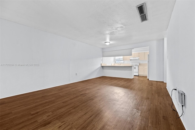 unfurnished living room featuring wood-type flooring and a textured ceiling