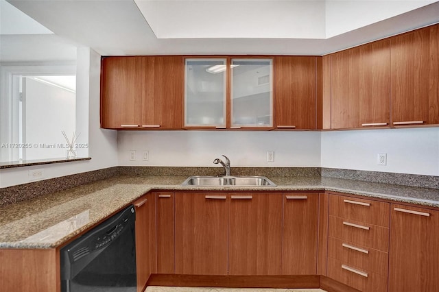 kitchen with dishwasher, stone countertops, and sink