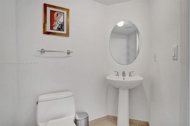 bathroom featuring tile patterned flooring, toilet, and sink