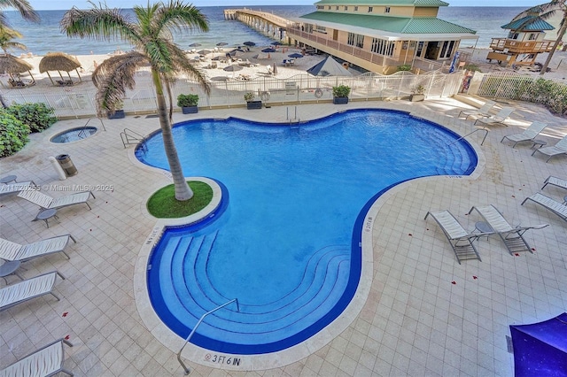 view of pool with a water view and a patio area