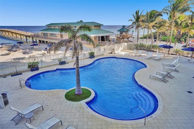 view of swimming pool with a patio and a water view