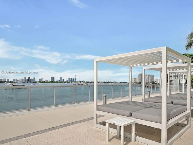 view of patio with a water view and a pergola