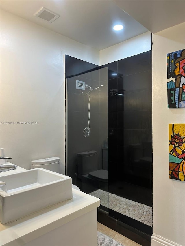 bathroom featuring tile patterned floors, a shower, and vanity