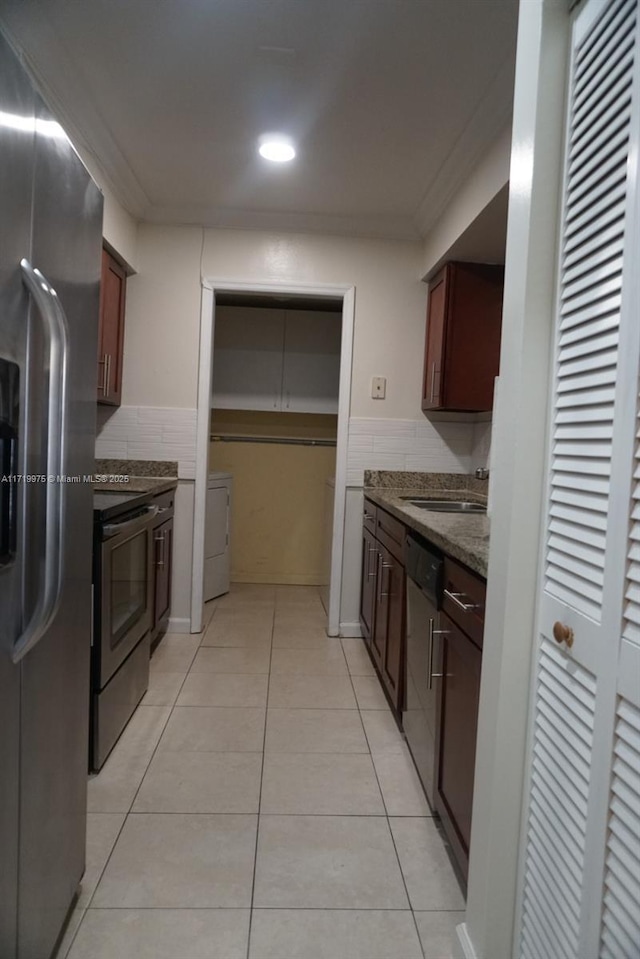 kitchen with light tile patterned floors, stainless steel appliances, ornamental molding, and sink