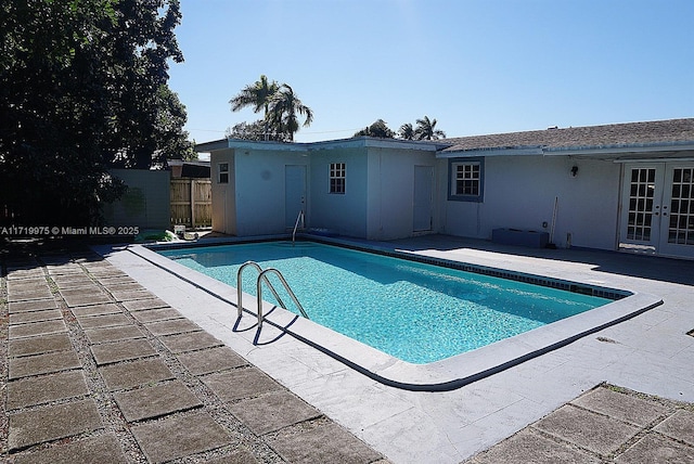 view of swimming pool with french doors and a patio