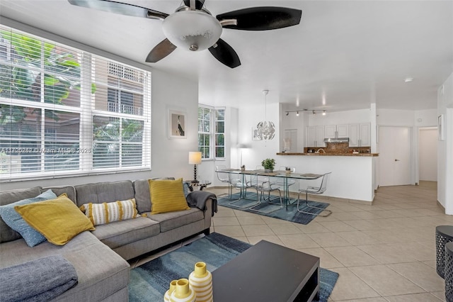 tiled living room featuring ceiling fan and a healthy amount of sunlight